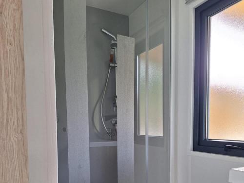 a shower in a bathroom with a glass door at Mobile Home in Austrian Countryside in Altossiach