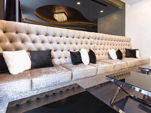a large couch in a room with pillows on it at Nova City Garni Hotel Signature Collection in Belgrade