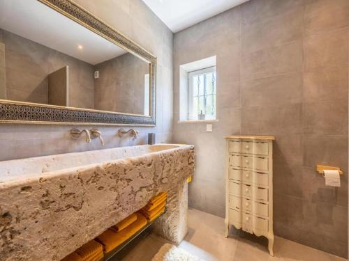 a bathroom with a large stone sink and a mirror at Private Bedroom in a Luxurious Villa, Budens in Budens