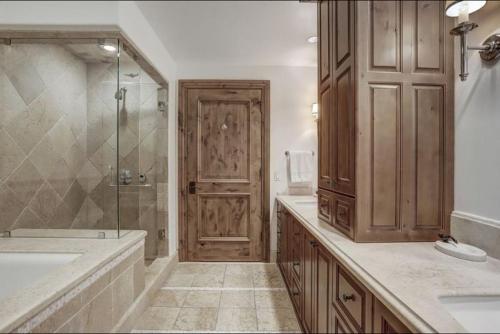 a bathroom with a shower and a tub and a sink at Platinum 4 Bedroom Vacation Rental In The Heart Of Vail That Includes Ski Valet, Ski Deck, Rooftop Pool, Panoramic Views in Vail