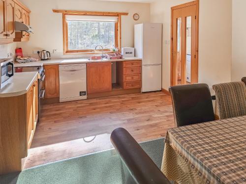 a kitchen with a sink and a refrigerator at Cotterton Beag in Nethy Bridge