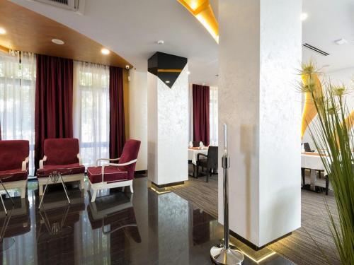 a conference room with red chairs and a table at Nova City Garni Hotel Signature Collection in Belgrade