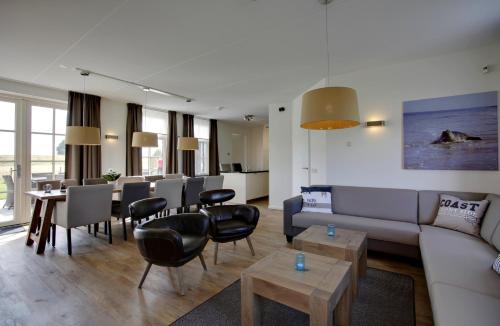 a living room with a couch and chairs and a table at Parc Ganuenta in Colijnsplaat