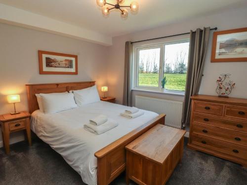 a bedroom with a bed with two towels on it at Mallard Cottage in Penrith