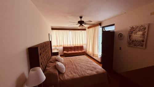 a bedroom with a bed and a ceiling fan at Flor y Canto Hotel in Matehuala