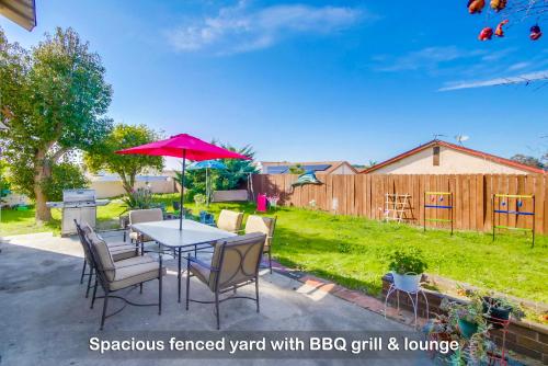 a patio with a table with chairs and an umbrella at Entire Private Home with 4 Bedrooms - 3 Bathrooms, Big Yard, Garage, King Bed, Crib, Available Now in San Diego