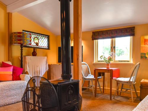 a living room with a wood stove in a room at Owls Nest in Stradbroke