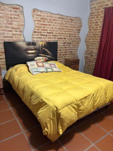 a bedroom with a yellow bed with a headboard at Casa de verano confortable in Villa Las Rosas