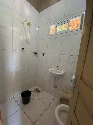 a bathroom with a toilet and a sink at Casa no Paracuru in Paracuru