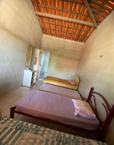 a bedroom with two beds and a wooden ceiling at Casa no Paracuru in Paracuru