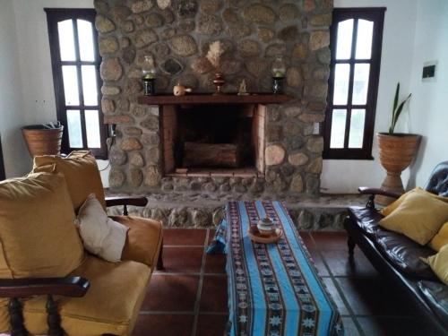 a living room with a couch and a fireplace at Habitaciones La Apacheta - El Mollar in Tafí del Valle
