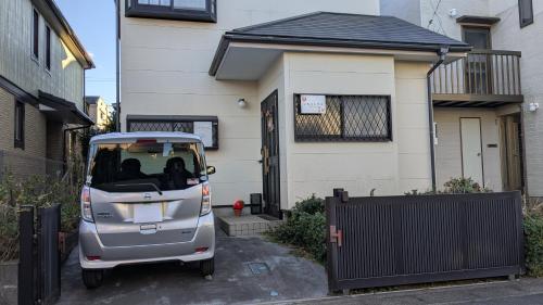 a small car parked in front of a house at いちごハウス in Zushi