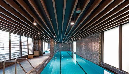 a swimming pool in a building with a large ceiling at Central 2BR Apt by Melbourne Central City Views in Melbourne