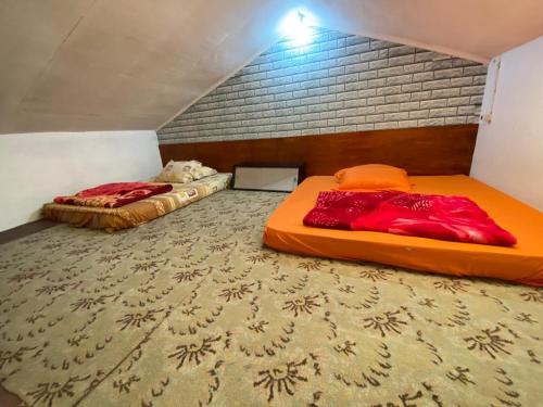 two beds sitting in a room with a mattress at DIENG GHUZY HOUSE syariah family room 3 kamar in Wonosobo