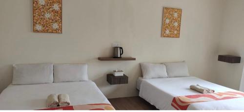 a bedroom with two beds with slippers on them at DamaiiKu in Cherating