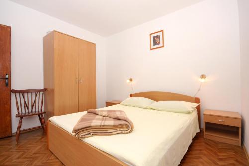 a bedroom with a bed with a blanket on it at Apartment Rogacic 2460b in Vis