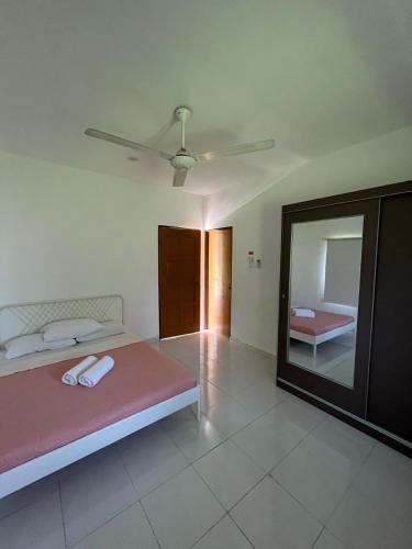 a bedroom with a large bed and a mirror at Suri Homestay, Taiping in Taiping