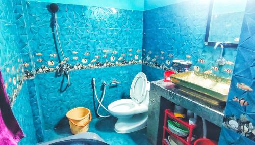 a blue bathroom with a toilet and a sink at DZ Homestay 1BHK in Dimāpur