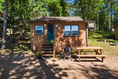 a tiny house with a picnic table and a picnic table at Whispering Waters Bayview Resort Cabin 4 in Saint Germain