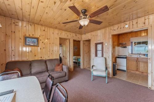 a living room with a couch and a ceiling fan at TB5 Thunder Bay Resort Cabin5 in Phelps