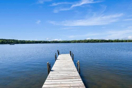 a dock on a lake with trees in the background at Bayview Resort Waters Edge Cabin 2 in Saint Germain
