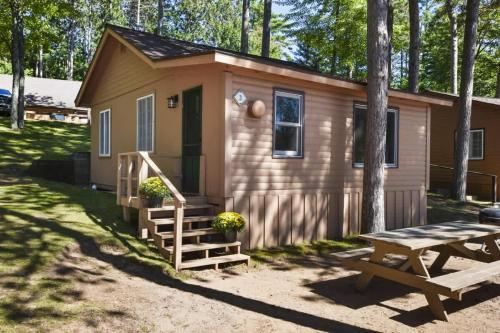 a tiny house with a picnic table in front of it at Bayview Resort Sandy Shores Cabin 3 in Saint Germain