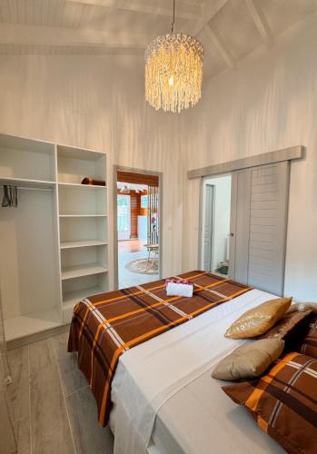 a bedroom with a large bed and a chandelier at Ti kè an mwen in Pointe-Noire