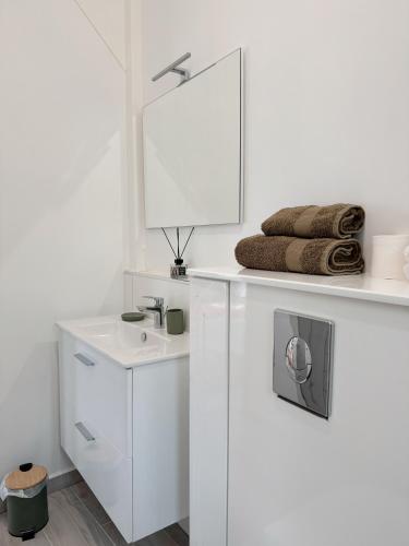 a white bathroom with a sink and a mirror at Ti kè an mwen in Pointe-Noire