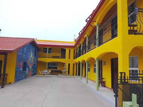 a yellow building with paintings on the side of it at Hotel Ecológico Temazcal in Creel