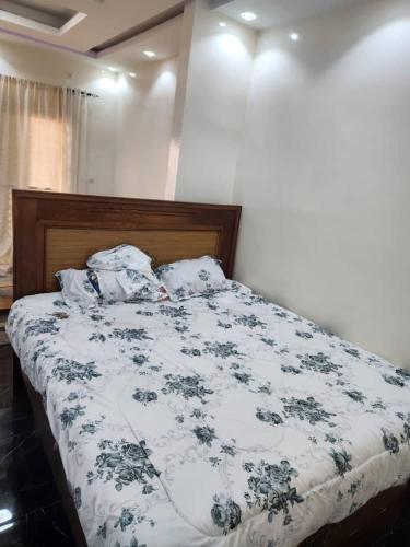 a bedroom with a bed with a blue and white comforter at Gassama studio in Dakar