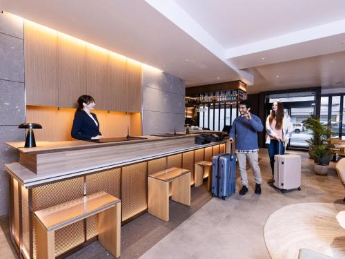two people standing at a bar in a restaurant at Tokyu Stay Sapporo in Sapporo