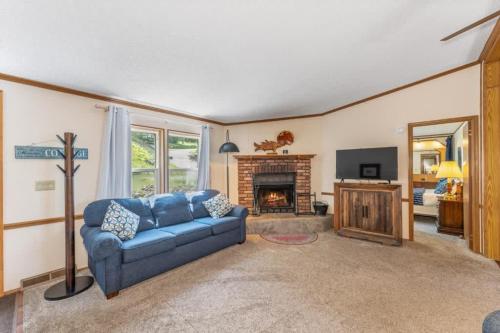 a living room with a blue couch and a fireplace at TB-15 Thunder Bay Resort Cabin15 in Phelps