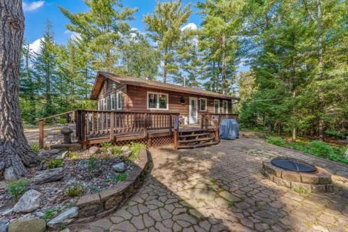 a log cabin in the woods with a fire pit at Clover Pines in Eagle River