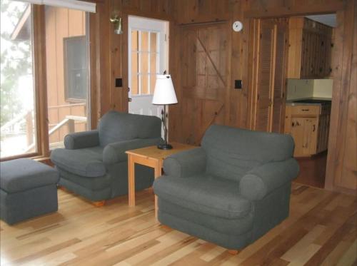 a living room with two chairs and a table at Bayview Resort Sunset Lookout Cabin 6 in Saint Germain