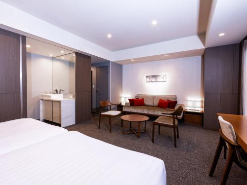a hotel room with a bed and a table at Tokyu Stay Sapporo in Sapporo