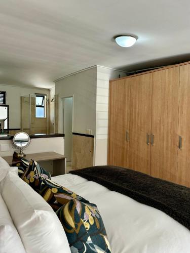 a bedroom with a large bed and wooden cabinets at Meerendahl Luxury Apartments at Tyger Lake in Cape Town