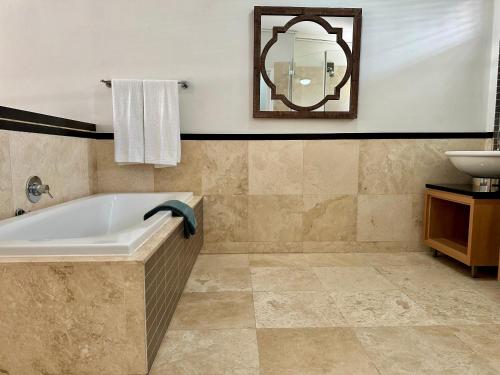 a bathroom with a bath tub and a sink at Meerendahl Luxury Apartments at Tyger Lake in Cape Town