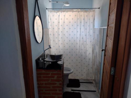 a bathroom with a toilet and a shower with a clock at chalé 8a 4 in Cunha