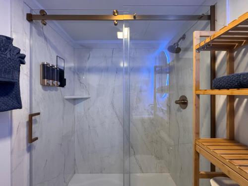 a shower with a glass door in a bathroom at Cuddle's Comfort & OCEAN in Daytona Beach