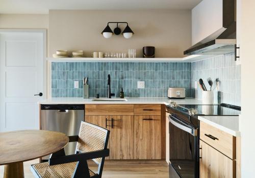 a kitchen with wooden cabinets and blue tiles at The Dylin in Madison