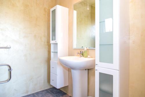 a bathroom with a white sink and a mirror at Arrowtown Dress Circle in Arrowtown