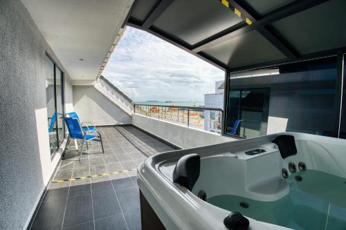 a bathroom with a tub and a view of the ocean at Royale Chulan Penang in George Town