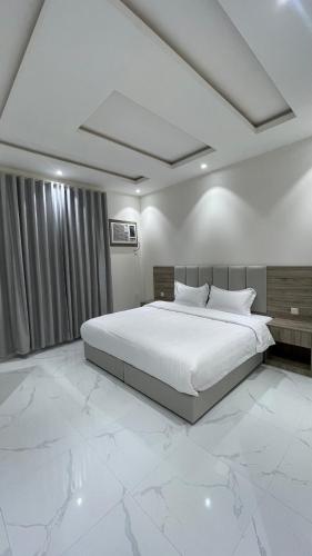 a bedroom with a large bed with white marble floors at غرفه - واڤا in Tabuk