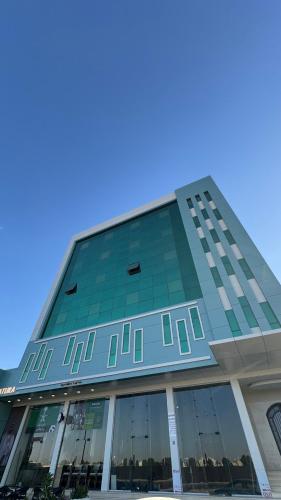 a tall glass building with a blue sky in the background at غرفه - واڤا in Tabuk