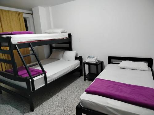 a room with two bunk beds and a chair at Hotel Galerias in Ruiosucio