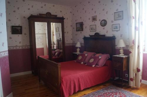 1 dormitorio con 1 cama con sábanas rojas y espejo en Le Domaine de Rochefort, en Dissangis