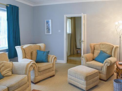 a living room with two chairs and a table at Sea View Cottage in Rhos-on-Sea