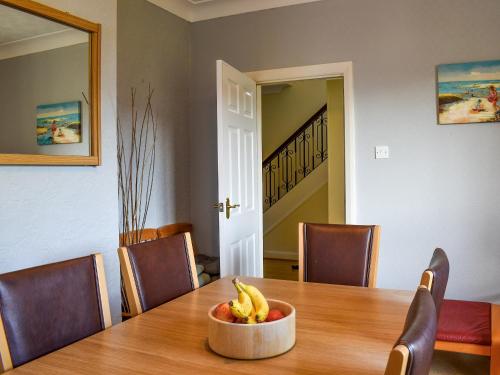 a bowl of bananas sitting on a wooden table at Sea View Cottage in Rhos-on-Sea