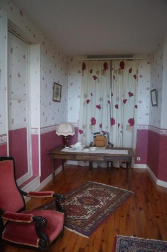 Cette chambre comprend une table et une chaise. dans l'établissement Le Domaine de Rochefort, à Dissangis