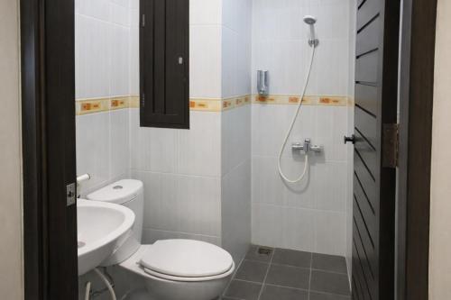 a bathroom with a toilet and a sink and a shower at Manggar Indonesia Hotel in Kuta